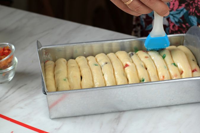 Female Hand Smearing Fresh Milk to Ready to Bake Bread