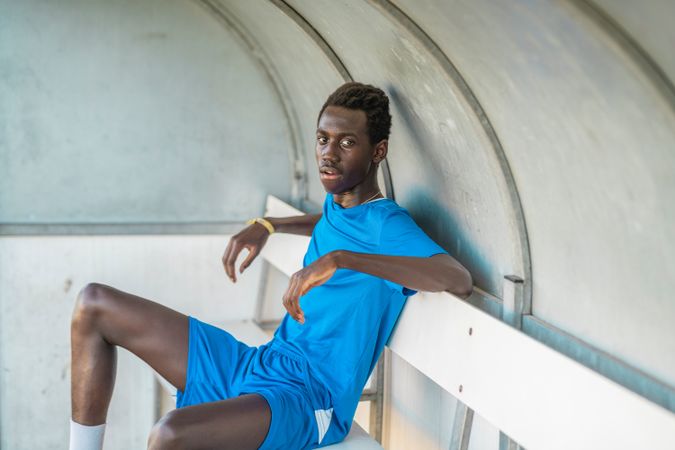 Black football player resting on bench