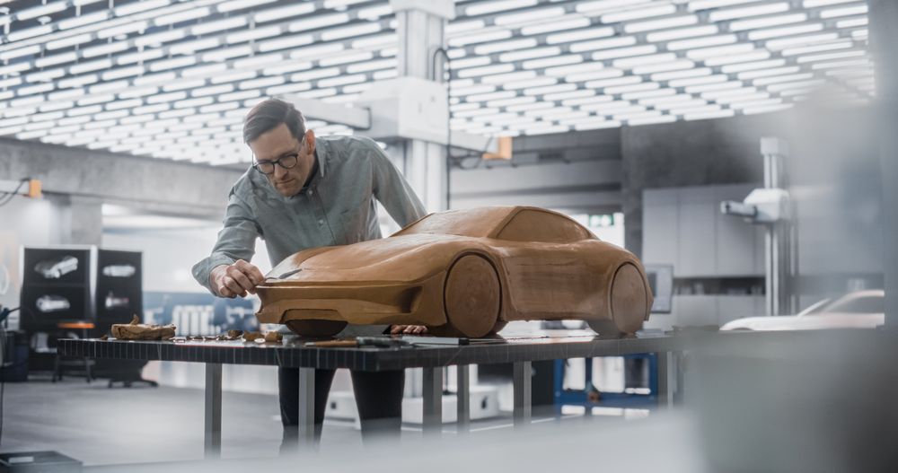 Car Modeler In Creative Workplace Working on a Concept Car Made Out of Plasticine Modeling Clay.