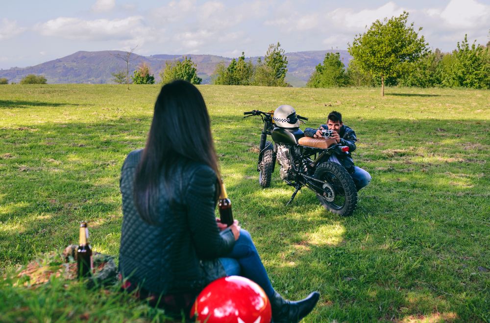 Couple resting from a motorcycle trip taking picture