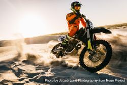 Male biker riding dirt bike on the sand in desert 5RA8R0