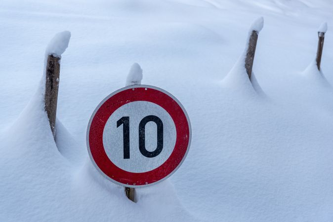 Speed limit road sign covered in snow in the Bavarian Alps, Germany