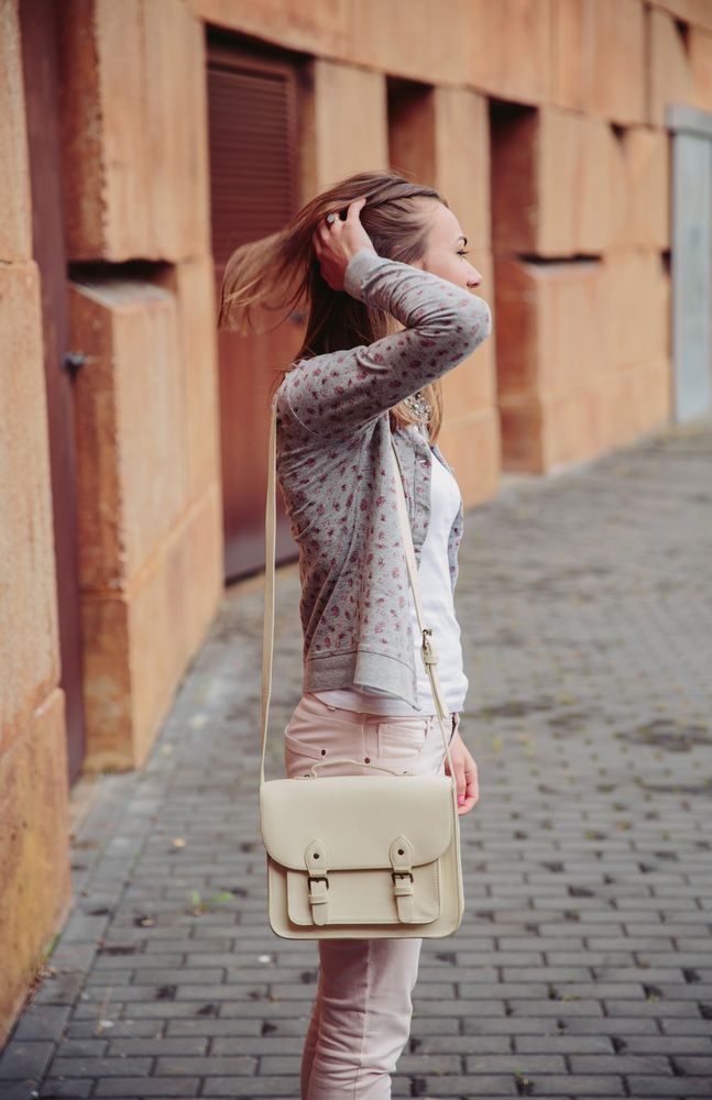 Side of woman standing on street with satchel bag