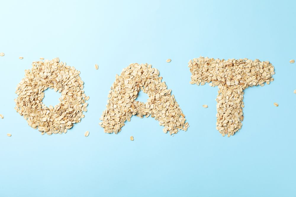 Text Oat made of oatmeal flakes on blue background
