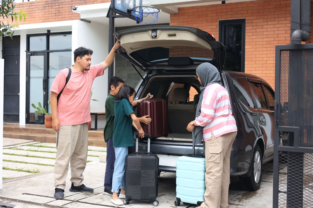 Happy Asian Muslim Family Put Suitcases in the Car Trunk Ready for the Mudik Lebaran Road Trip or Pulang Kampung