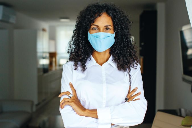 Portrait of confident woman in facemask with her arms crossed