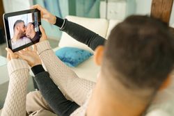 Male couple taking a selfie while kissing on sofa