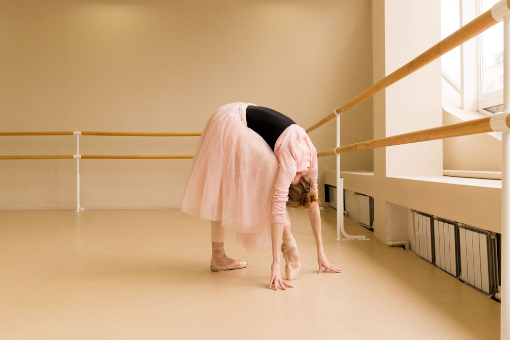 Ballet dancer bending forward in pink tutu