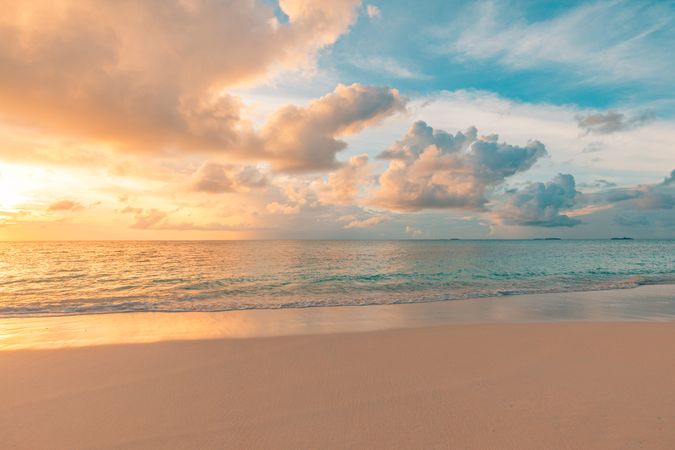 Beautiful beach at sunset with fluffy clouds