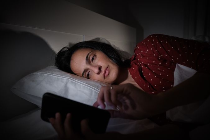 woman surfing smartphone at night time