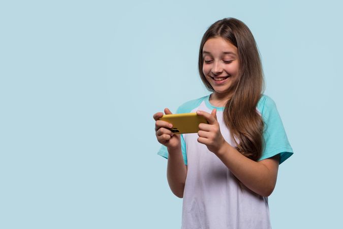 Girl using phone, enjoying engaging moment on screen.