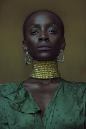 Portrait of Black woman in golden choker necklace and green top