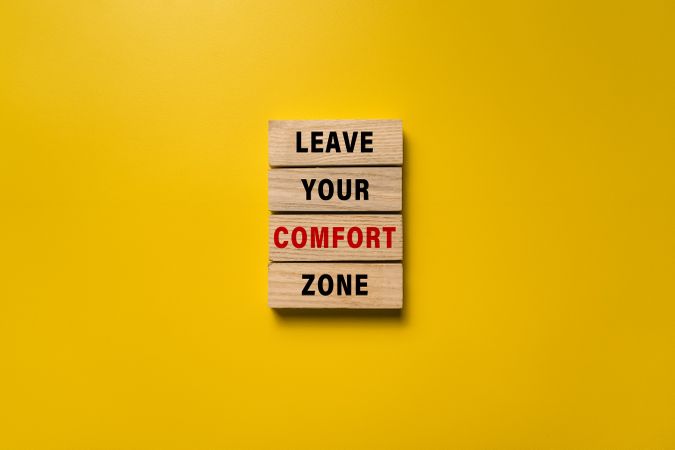 leave your comfort zone words on wooden blocks isolated on yellow background