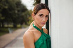 Barefoot woman leaning on house wall