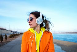 Woman in colorful clothes wearing headphones on the promenade