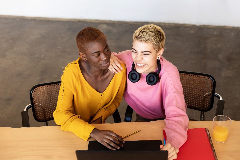 Female friends laughing together at breakfast table