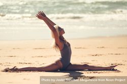 Woman doing splits on a beach near the ocean 5zeGA0