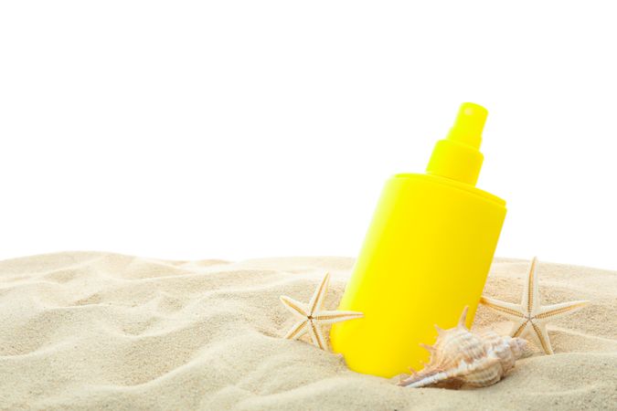 Sunscreen with starfish and seashells on clear sea sand isolated on blank background. Summer vacation