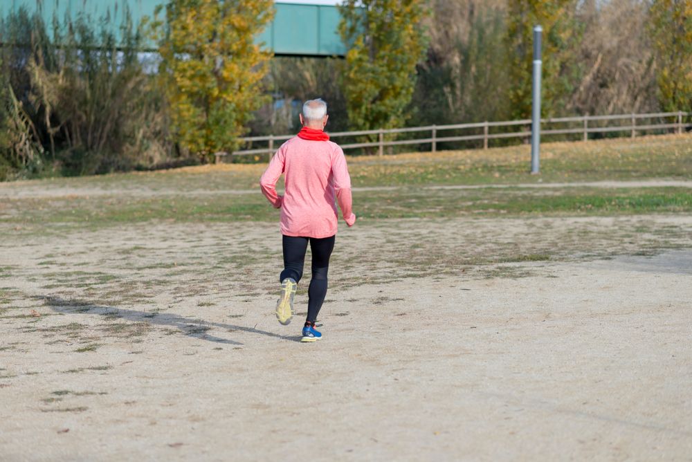 Back of older man jogging outside