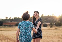 Taking advantage of life Grandmother and granddaughter in a field of sunflowers.