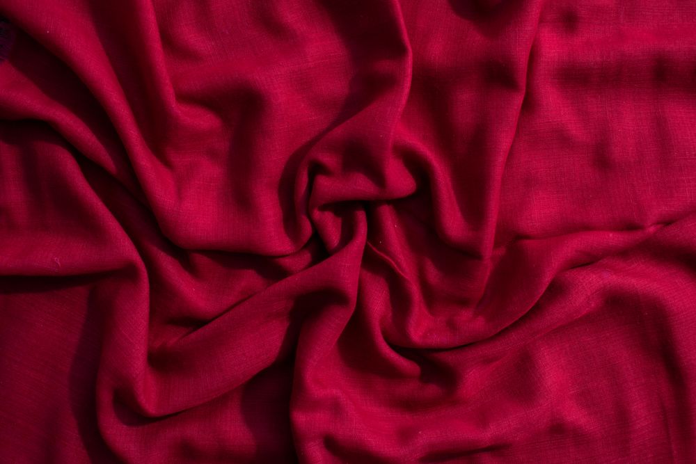Red fabric wavy crumpled background texture.