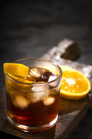 Negroni cocktail with orange, on dark background.