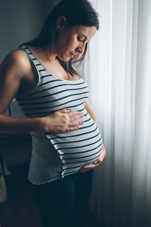 Pregnant woman looking her belly
