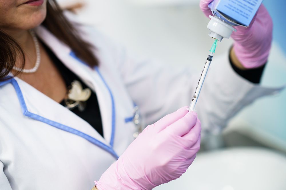 Female doctor filling up syringe