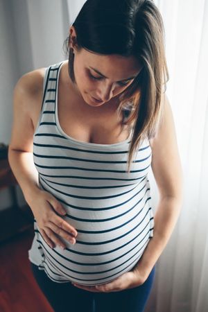 Pregnant woman looking her belly