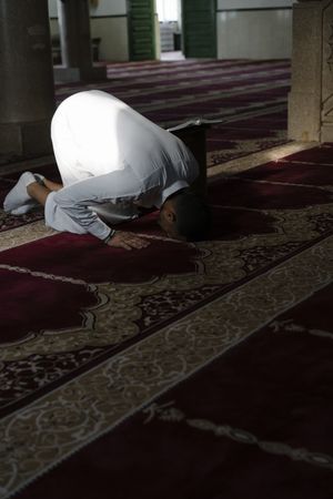 Man praying in mosque during daytime