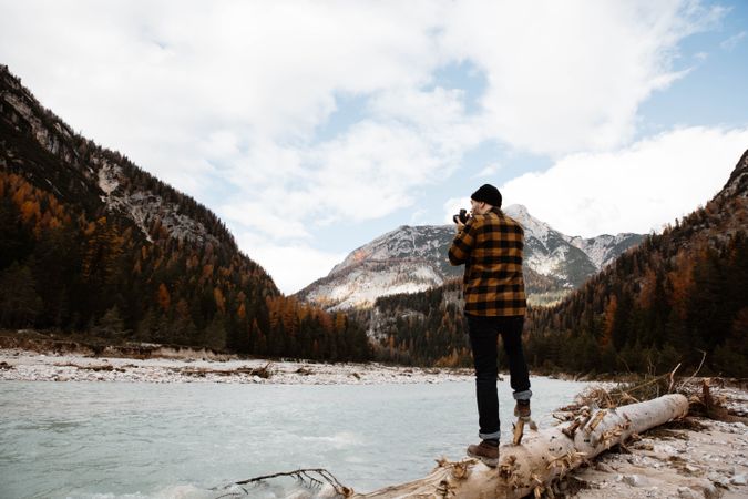 Man delighting in views near lake and mountains
