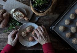 Person rolling in breadcrumbs sweet potatoes