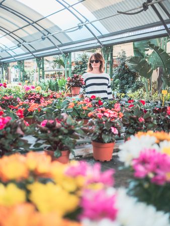 Female customer choosing flowers in greenhouse