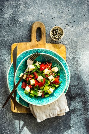 Healthy Greek salad with fresh vegetables, cubed cheese served with sesame seeds