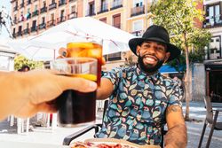 Black man having a drink in a bar terrace