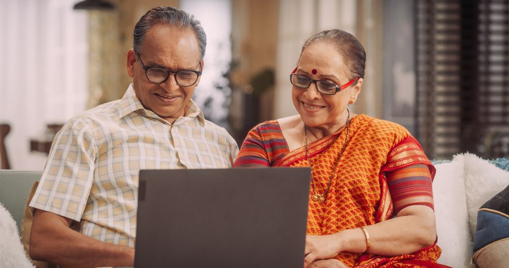 Older Indian Couple Browsing Websites for Clothing, Products Sales, Choosing Best for Online Shopping.