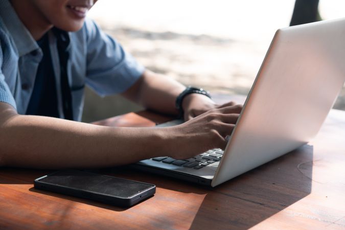 Close Up Asian Young businessman work at outdoor with laptop. Concept of remote and freelance work. Young successful man wearing casual blue cloth.
