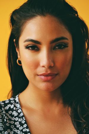 Serious Hispanic woman wearing dress in yellow room, vertical