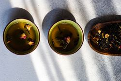 Two cups of green tea and tea leaves