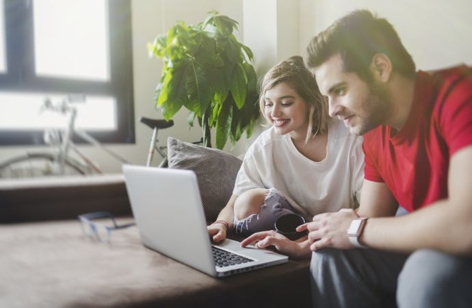 Couple browsing laptop on couch