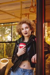 Woman on public transport with takeaway coffee