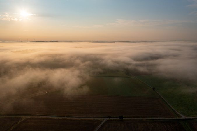 Sunrise scenery from above with foggy agricultural fields at golden hour