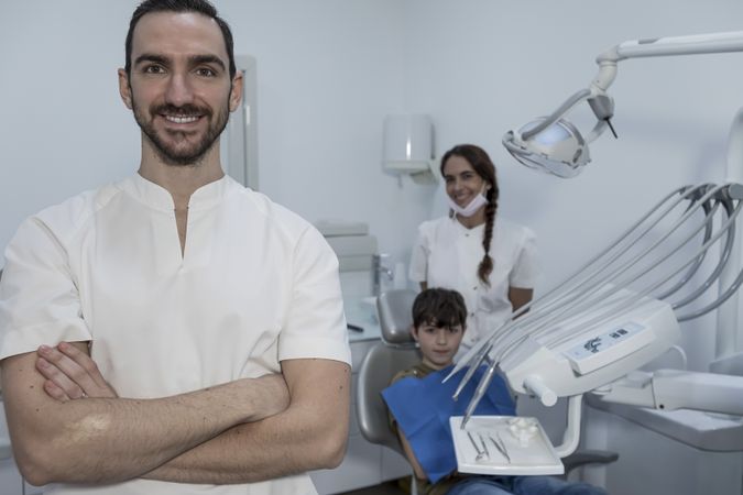 Dentist standing with arms crossed in clinic