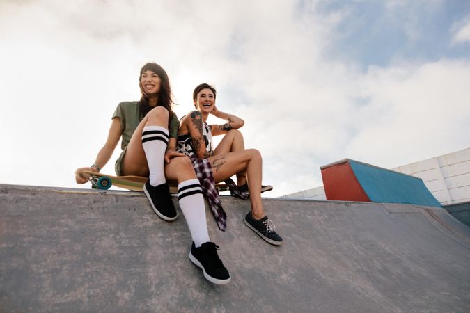 Two women in skate park laughing and having fun