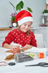 Smiling girl applying icing on gingerbread cookie