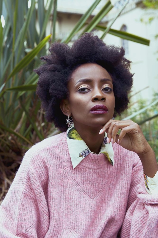 Woman in pink sweater wearing big earrings