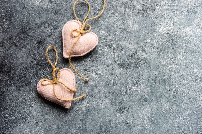 Two pink heart ornaments on grey counter