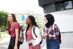 Happy multi-ethnic students walking to class