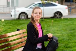 Girl packing her backpack in park.