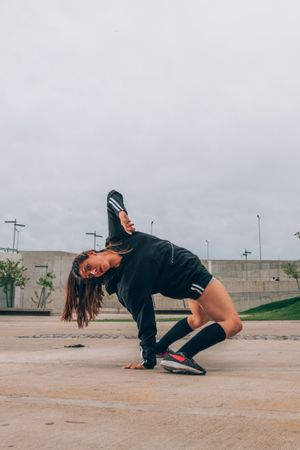Female hip hop dancer in active wear striking pose outdoors